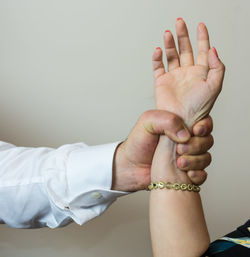 Cropped image of man gripping woman hand