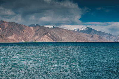 Scenic view of sea and mountains against sky