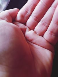 Close-up of father holding baby hand