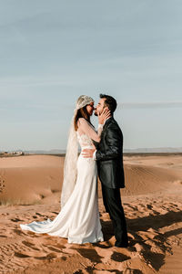 Rear view of couple kissing on beach