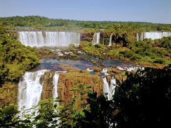 Scenic view of waterfall against sky