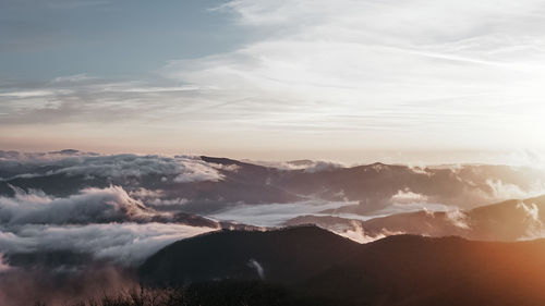 Scenic view of majestic mountains against sky during sunset