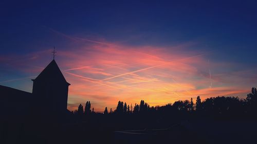 Silhouette buildings against sky during sunset