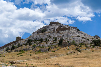 Built structure on rocky mountain against sky