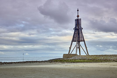 Lighthouse by sea against sky