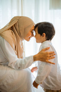 Side view of mother and daughter at home