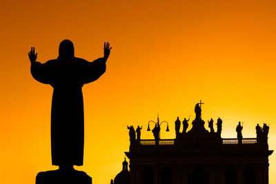 Silhouette statue against sky during sunset