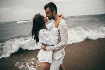 Full length of couple standing at beach