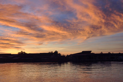 Scenic view of river against sky at sunset