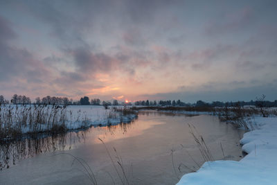 Scenic view of lake against sky during winter