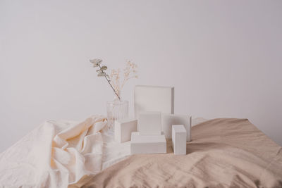 White flower vase on table against wall at home