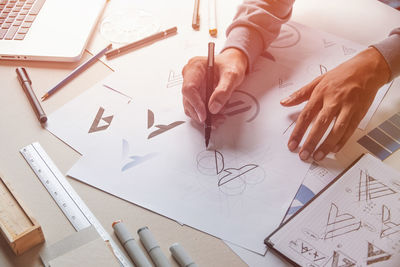High angle view of woman drawing on paper