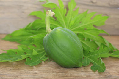 Papaya with leaves on old wood floor.