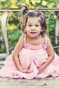 Portrait of smiling girl sitting outdoors