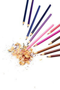 High angle view of multi colored pencils on white background