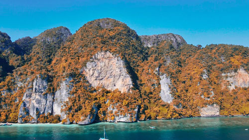 Rock formations in sea against blue sky