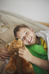 Portrait of smiling boy holding stuffed toy