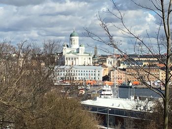 View of cityscape against cloudy sky