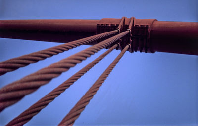 Low angle view of pipe against clear blue sky