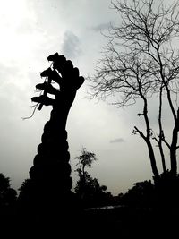 Low angle view of silhouette statue against sky