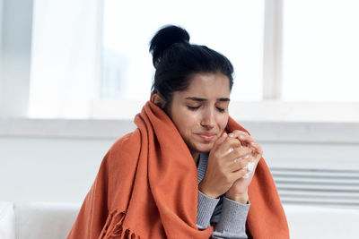 Mid adult woman looking away while sitting on floor