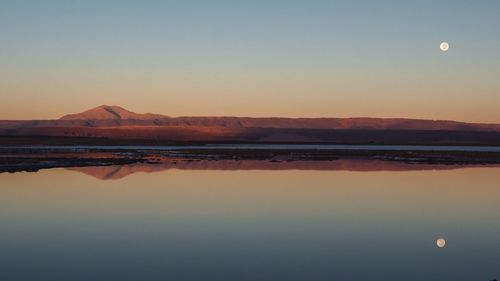 Scenic view of lake against clear sky during sunset