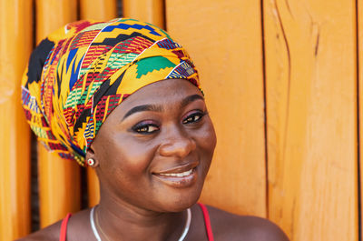  woman with a hopeful happy smile and traditional headdress  in the tropical village of keta ghana,