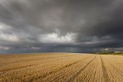 Scenic view of agricultural field against storm clouds