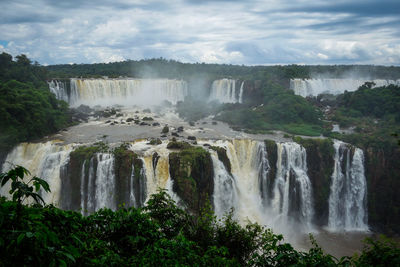 Scenic view of waterfall against sky