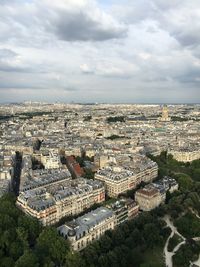 Aerial view of cityscape against cloudy sky