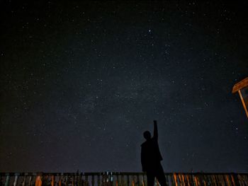 Man standing against star field at night