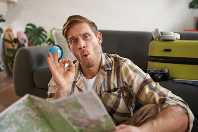 Portrait of boy blowing bubbles while sitting at home