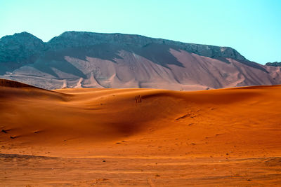 Scenic view of desert and mountains against sky