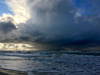 Scenic view of sea against storm clouds