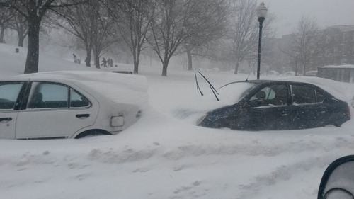 Close-up of snow covered car on road