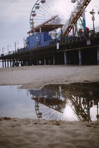 Ferris wheel at beach against sky