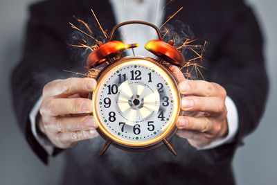 Close-up of hand holding clock