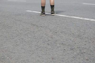 Low section of man standing on road