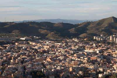 Aerial view of city and mountains against sky