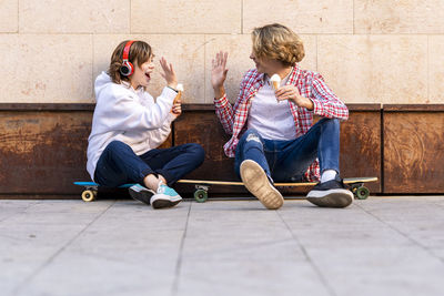 Rear view of friends sitting on floor