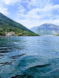 Scenic view of lake by mountains against sky