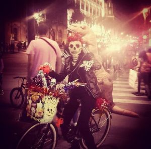 People riding bicycles on street at night