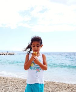 Full length of girl standing on beach against sky