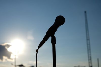 Close-up of microphone against sky on sunny day