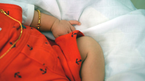 Midsection of baby lying down on bed