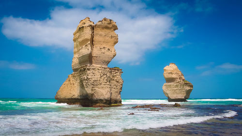 Rock formation on beach against sky