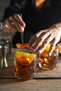 Midsection of woman holding drink on table