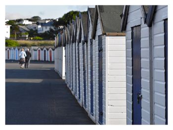 Rear view of couple beside beach huts