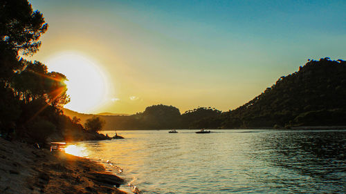 Scenic view of lake against clear sky during sunset