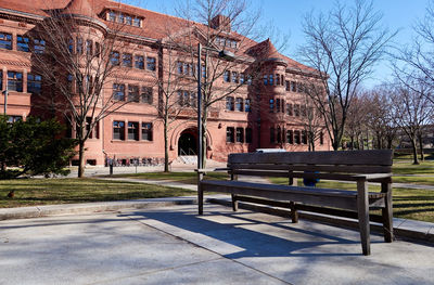 Bench in city against sky